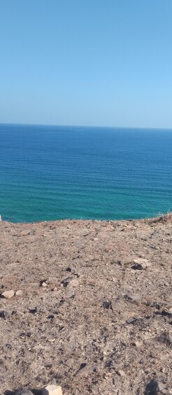 A rocky coastline with clear blue sea under a clear sky. 3