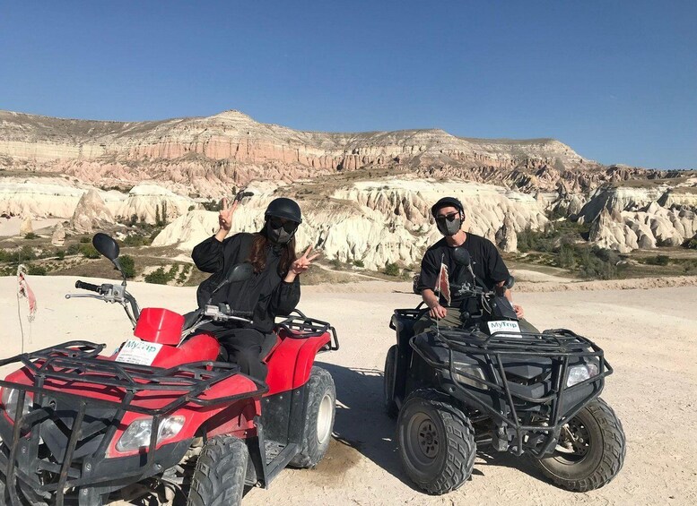 Two people on ATVs in a rocky, desert landscape. 3
