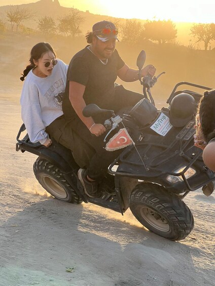 A person riding an ATV with a passenger. 2