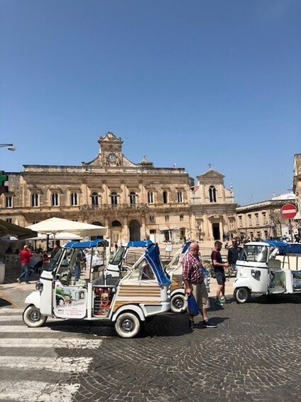 A street with vintage cars and pedestrians. 2