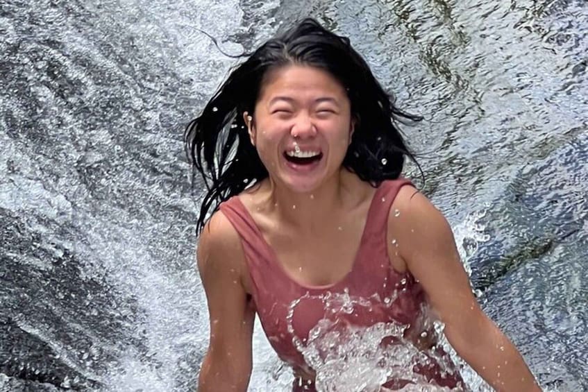 A person in a red tank top splashing in water. 5