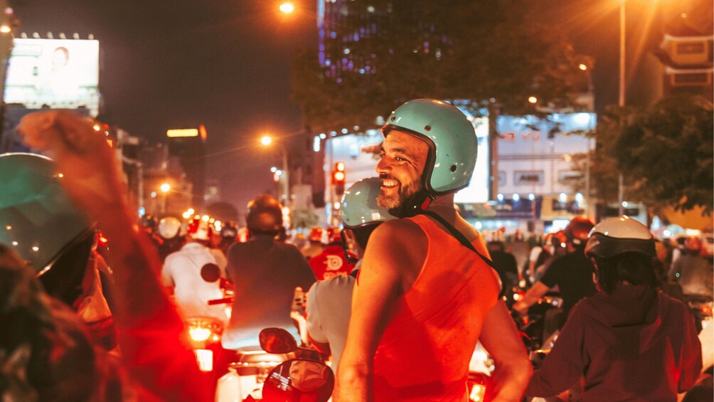 A nighttime street scene with people wearing helmets and reflective vests, indicating a possible event or protest. 2