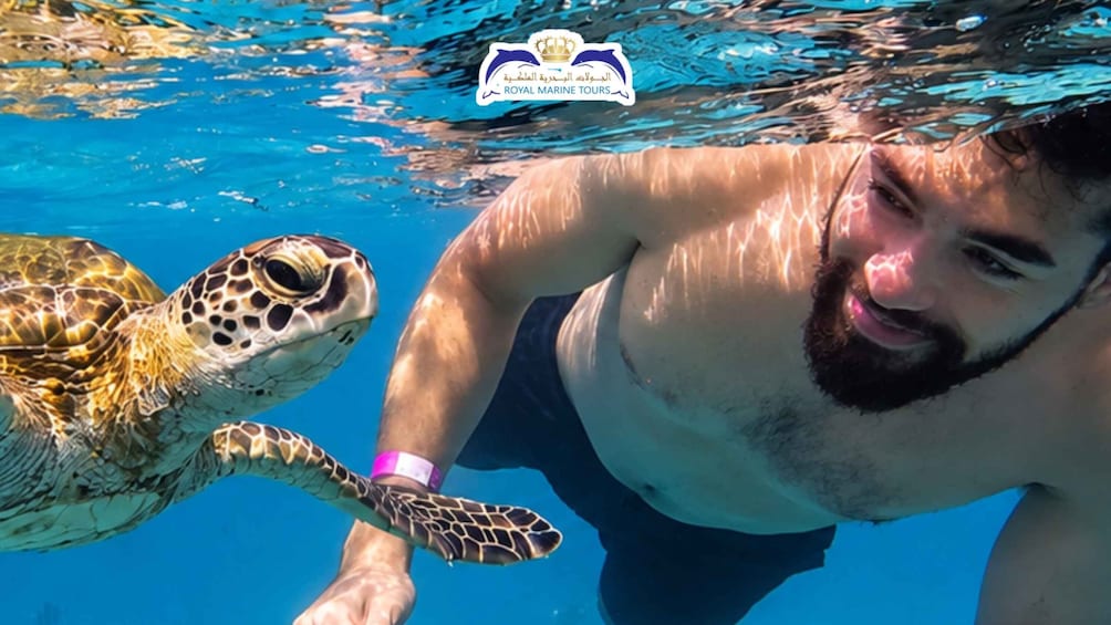 A person swimming with a sea turtle, underwater. 1