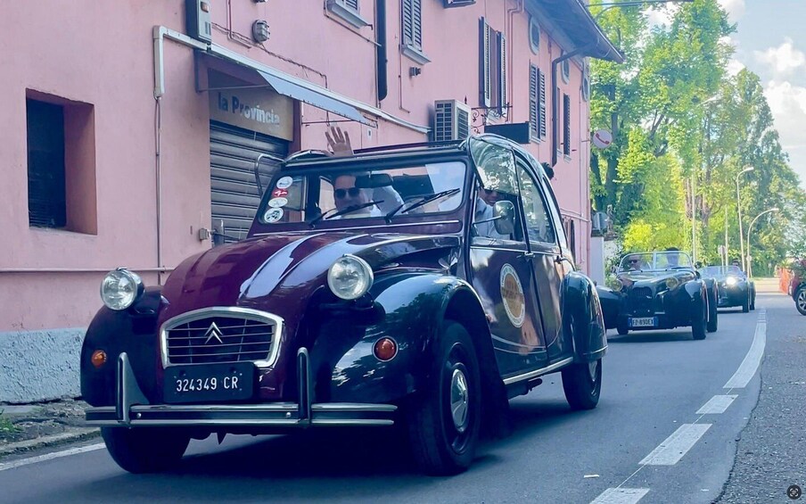 A vintage black car with a license plate 324349 CR driving on a street. 4