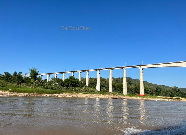 A large bridge over a river with greenery and hills in the background. 2