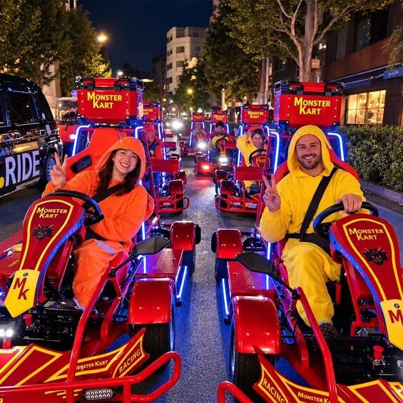 People riding Monster Kart vehicles on a city street at night. 4