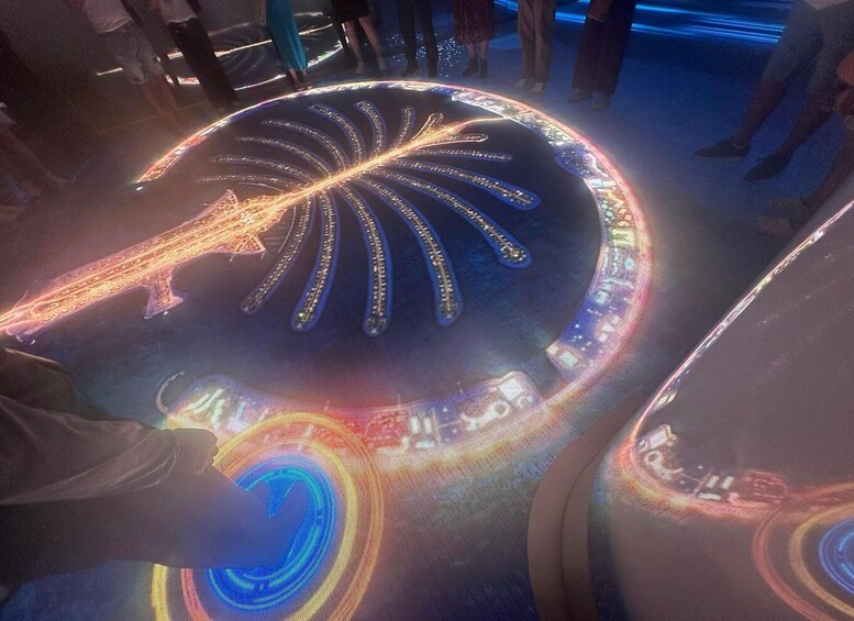 A large, illuminated, circular structure with a central design resembling a leaf or flower, surrounded by a glowing, intricate pattern. 5