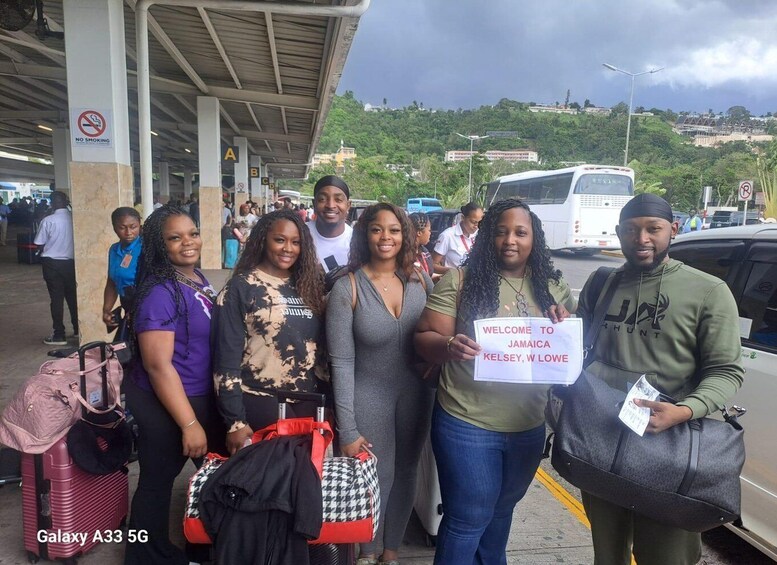 A group of people at an airport with luggage, a 'NO SMOKING' sign, and a 'WELCOME TO JAMAICA KELSEY, W. LOWE' sign. 4