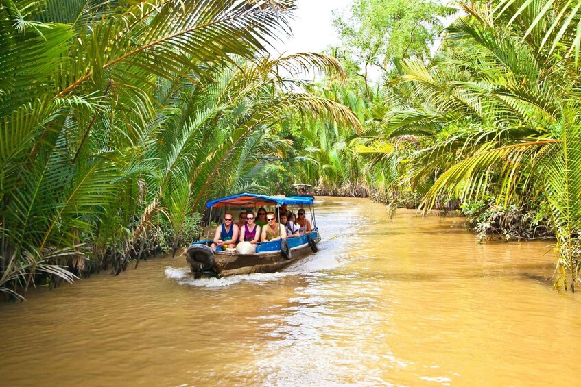 A boat with passengers navigating a river surrounded by dense tropical vegetation. 5