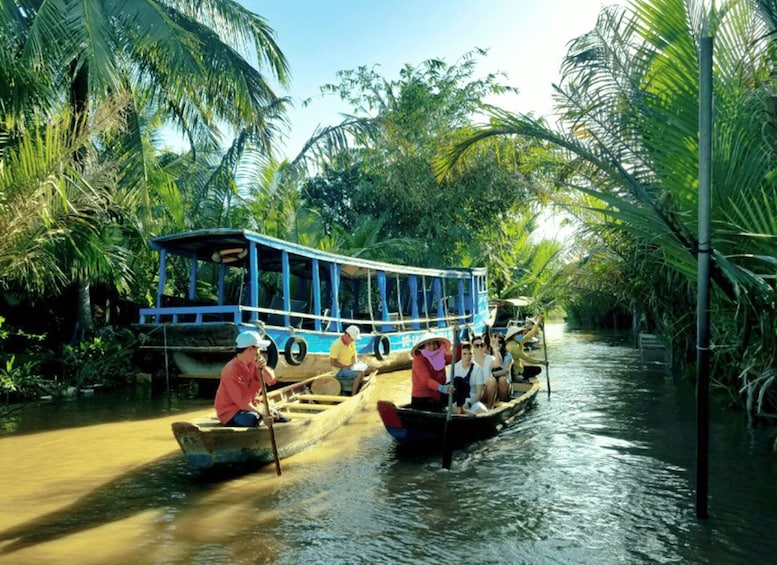 A riverboat tour with passengers and a guide, surrounded by lush tropical vegetation. 3