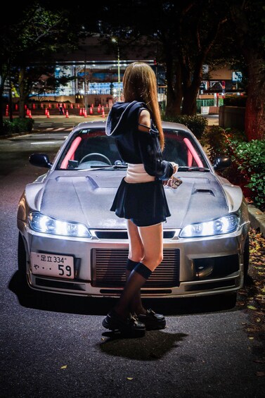 A person standing next to a car with a license plate number 33459. 4
