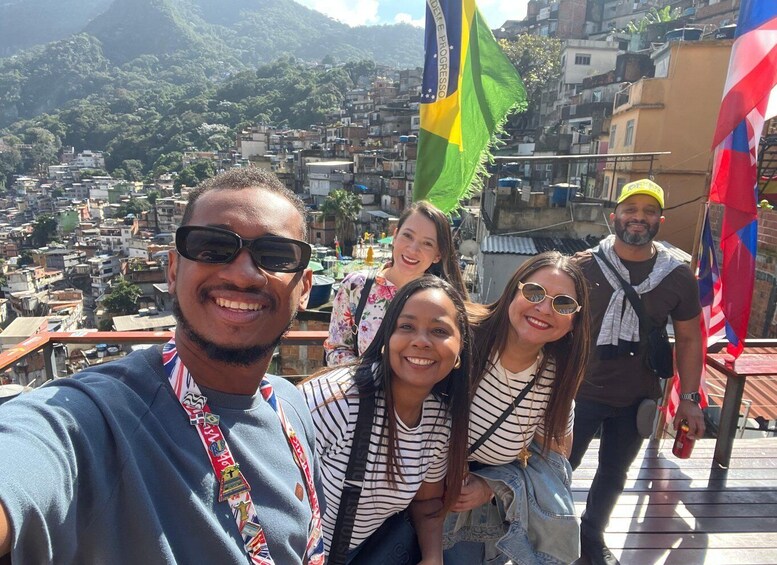 A group of people taking a selfie with a cityscape and mountains in the background. 2