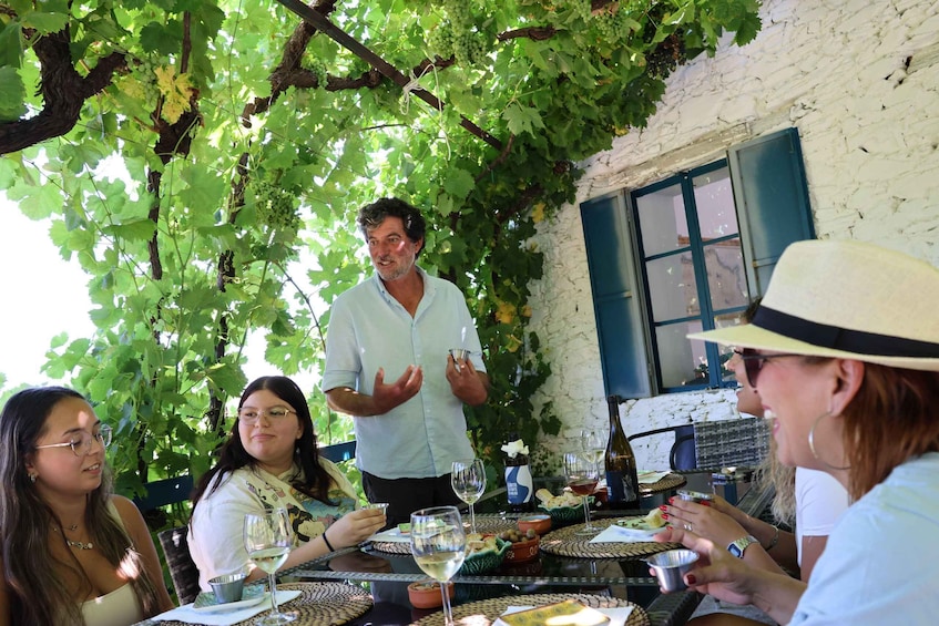 A group of people dining outdoors with a man speaking to them. 4