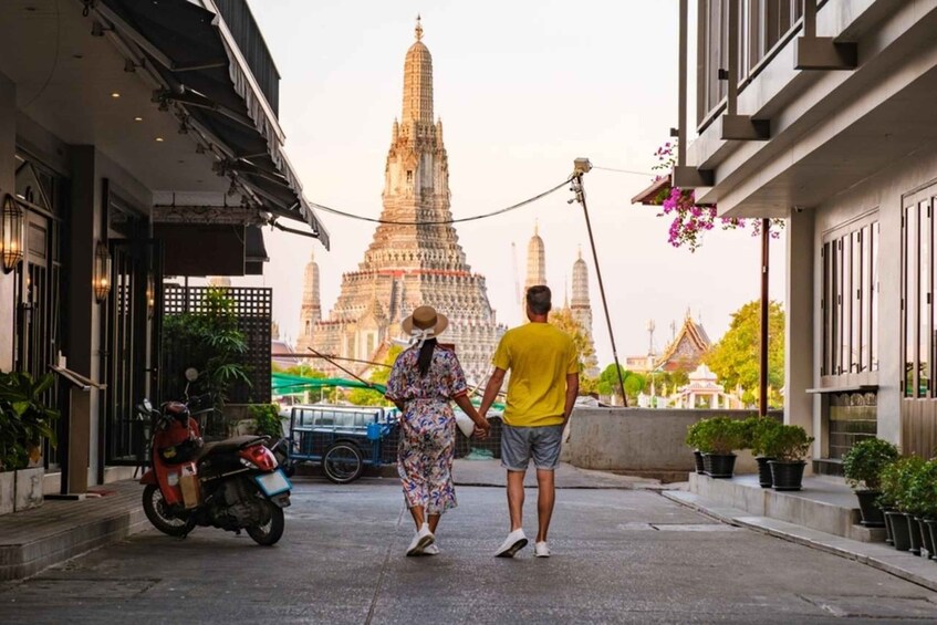 A couple walking on a street with a temple in the background. 5