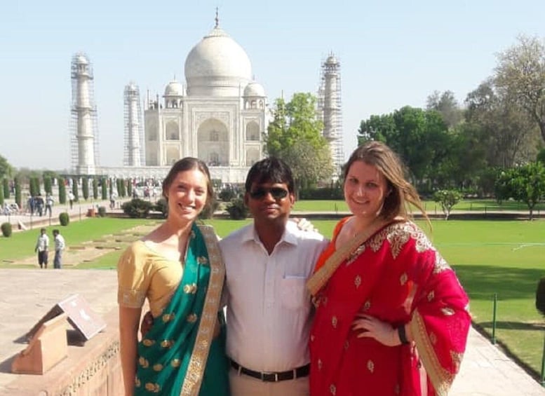 Tre persone davanti al Taj Mahal, con le cupole e i minareti visibili. 4