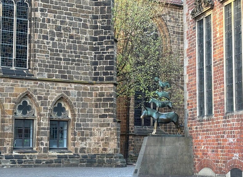A stone building with arched windows and a statue of deer. 1
