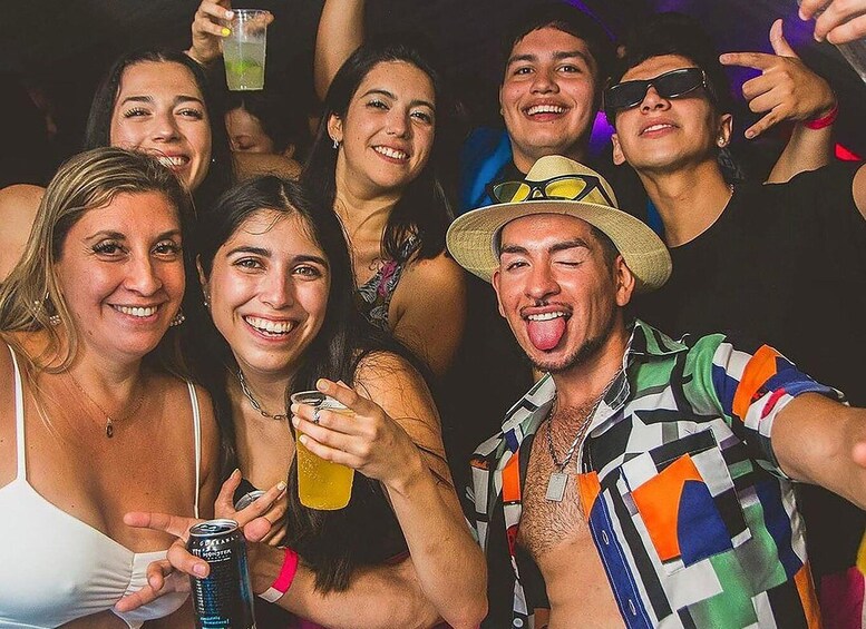 A group of people at a party, holding drinks and posing for a photo. 2