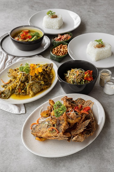 A variety of dishes including fried fish, rice, and a vegetable curry. 2
