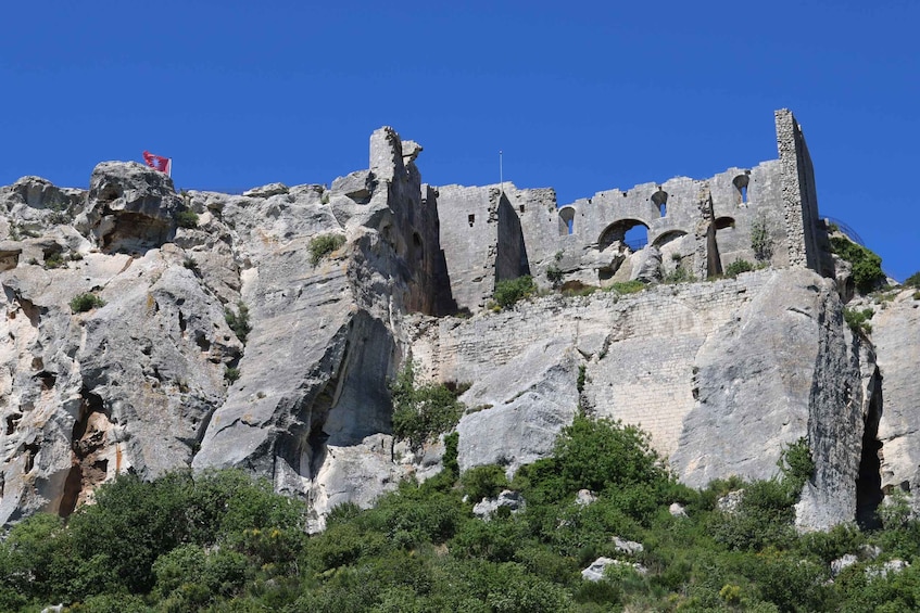 A rocky cliff with ancient ruins and a flag. 4