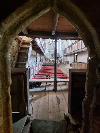 An arched doorway leading to a church interior with wooden pews and a central altar. 5