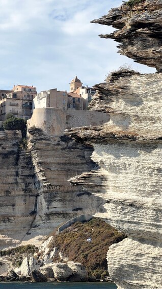 A coastal town built on a cliff with buildings and a tower. 3