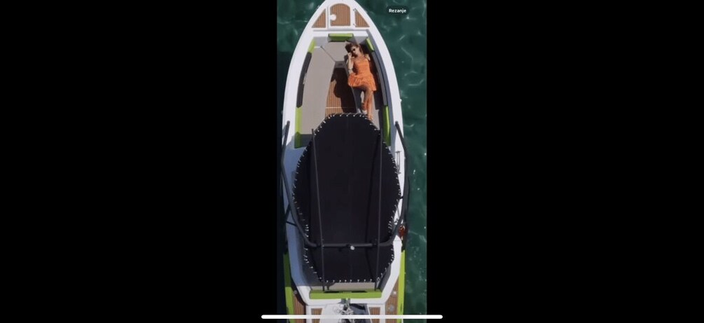 A boat with a person in an orange dress standing at the stern. 3