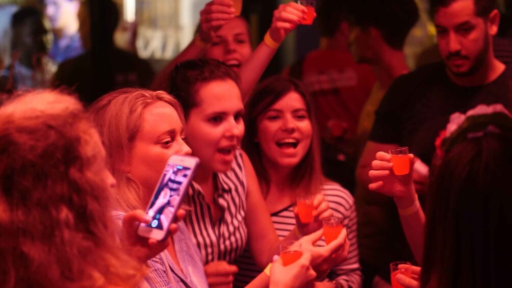 A group of people at a social event, some holding drinks. 5