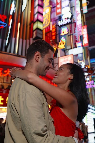 A couple embracing in a neon-lit urban setting. 5