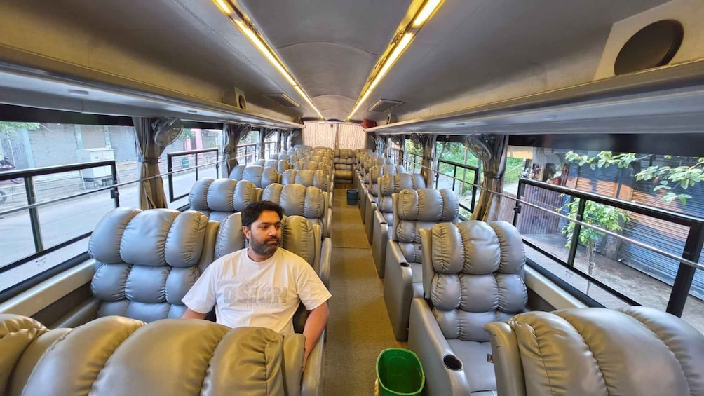 A train interior with leather seats and a person seated in the middle. 4