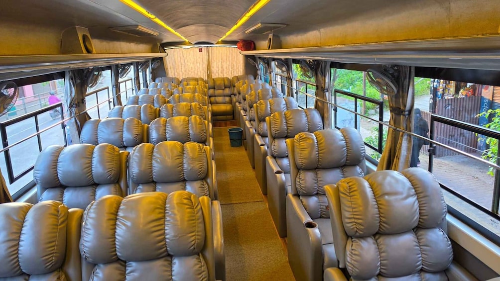A train interior with rows of leather seats and windows. 3