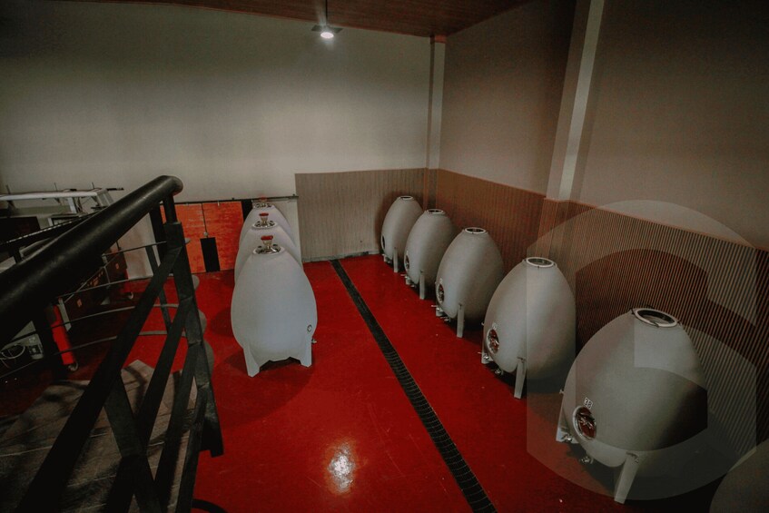 A red carpeted area with several large, white, cylindrical objects lined up. 2