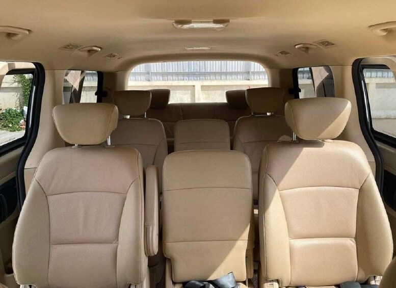 The interior of a car with beige leather seats and a sunroof. 5