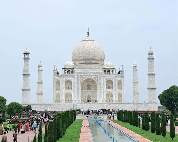 The Taj Mahal with four minarets, a large central dome, and a symmetrical garden with a water channel. 1