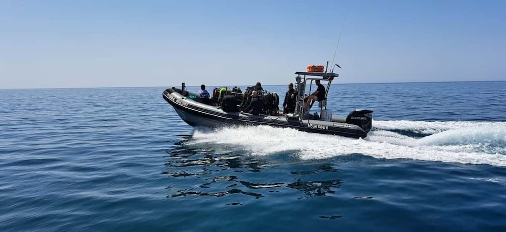 A motorboat with several people on board, moving through a body of water. 4