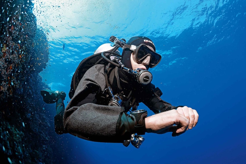 A diver underwater with a camera and a breathing apparatus. 1