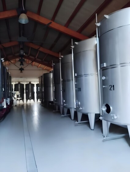 Stainless steel fermentation tanks numbered 20 and 21 in a warehouse. 2
