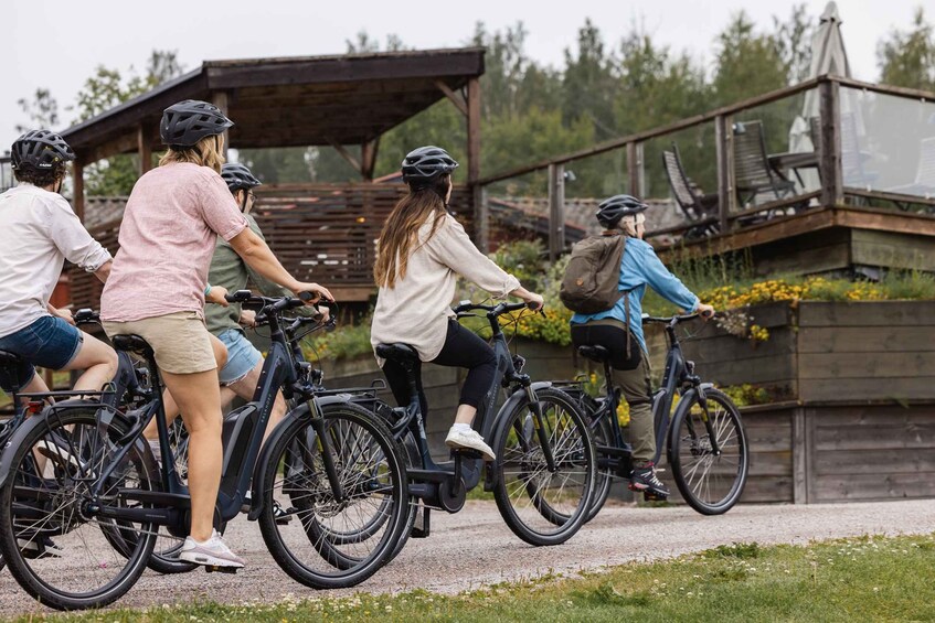 A group of people riding bicycles on a paved path. 1