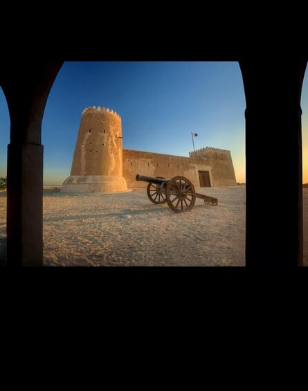 A historical fort with a large cannon and a watchtower. 1