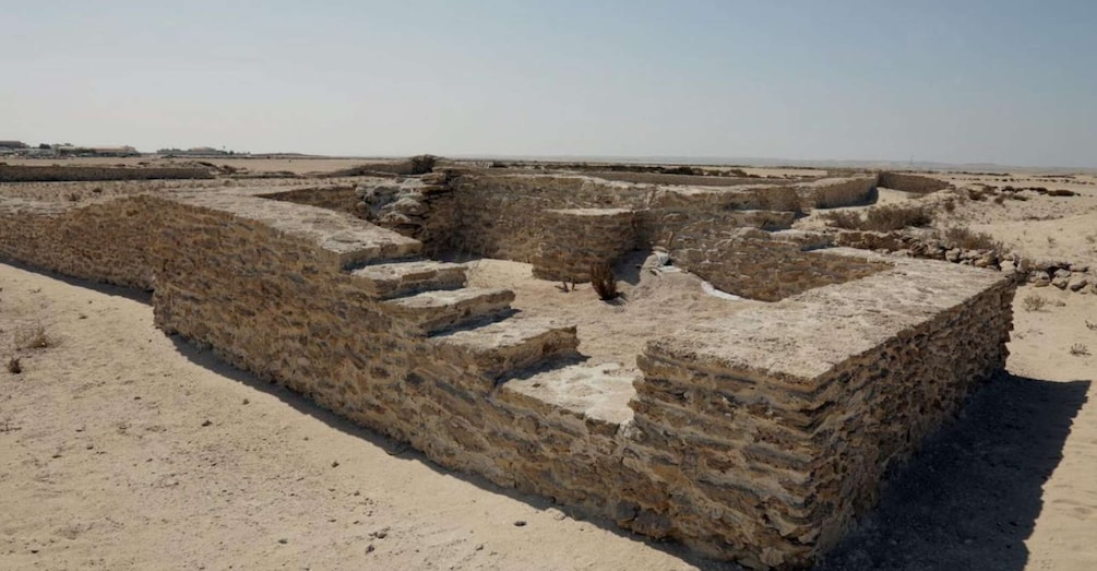 Ancient ruins with stone walls and steps in a desert landscape. 5