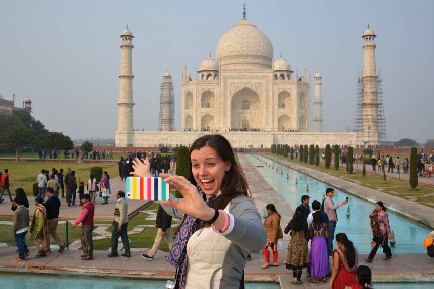 A person taking a selfie with the Taj Mahal in the background. 2