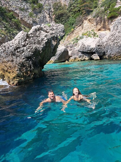 Deux personnes nagent dans une piscine aux eaux d’un bleu limpide, entourée de falaises rocheuses. 3