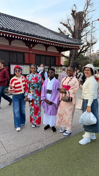 A group of people in traditional attire standing in front of a building with a tiled roof. 3
