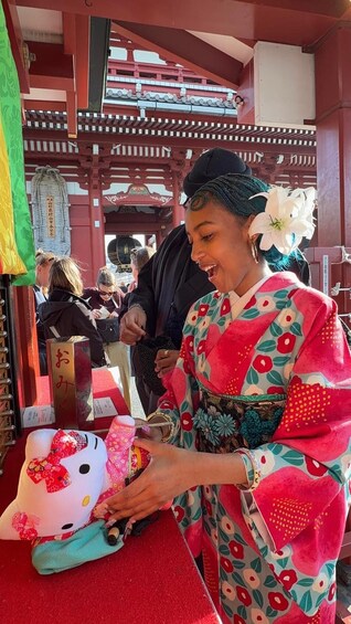 A person in traditional attire at a shrine, holding a ceremonial object. 2