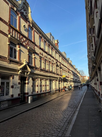 A cobblestone street lined with historic buildings, some with visible graffiti. 4