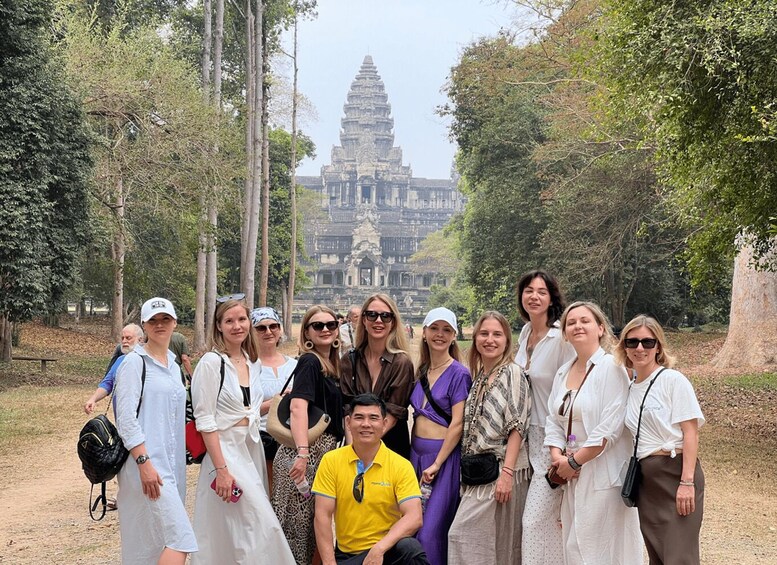 A group of people posing in front of Angkor Wat temple. 1
