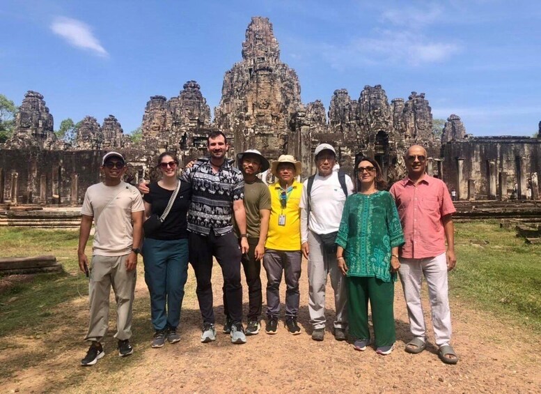 A group of people standing in front of Angkor Wat temple. 1