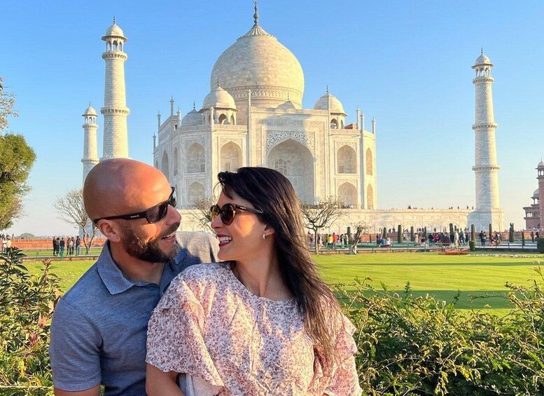 A couple in front of the Taj Mahal with its four minarets and large dome. 1