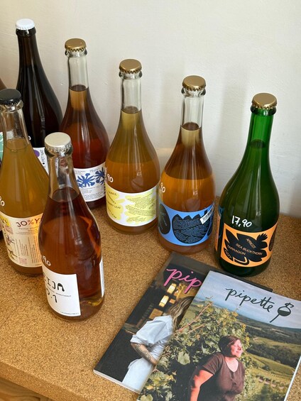 A variety of wine bottles and a book on a corkboard. 2