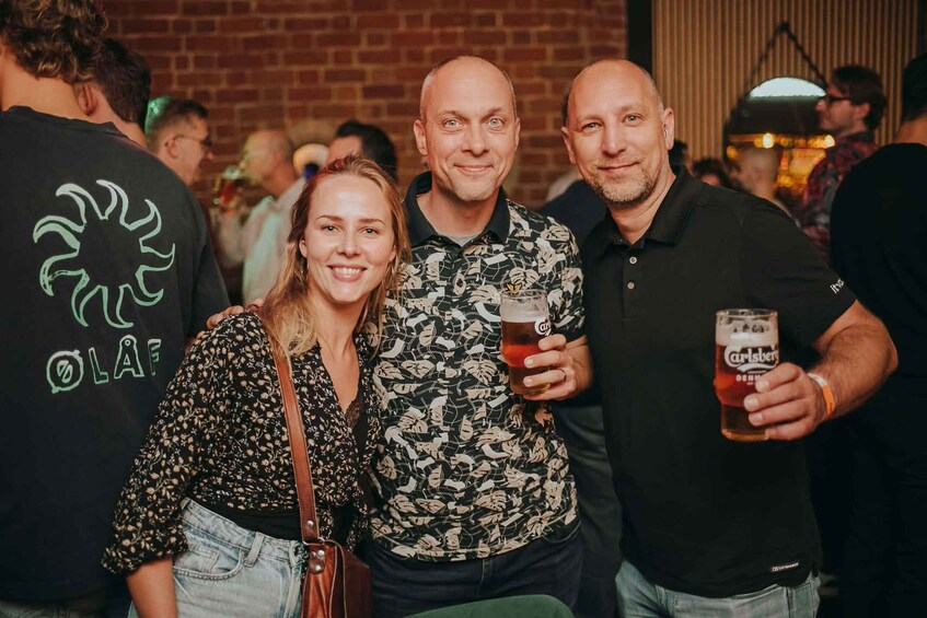 Un grup de persones en una reunió social, amb una persona agafant un got de cervesa. 5