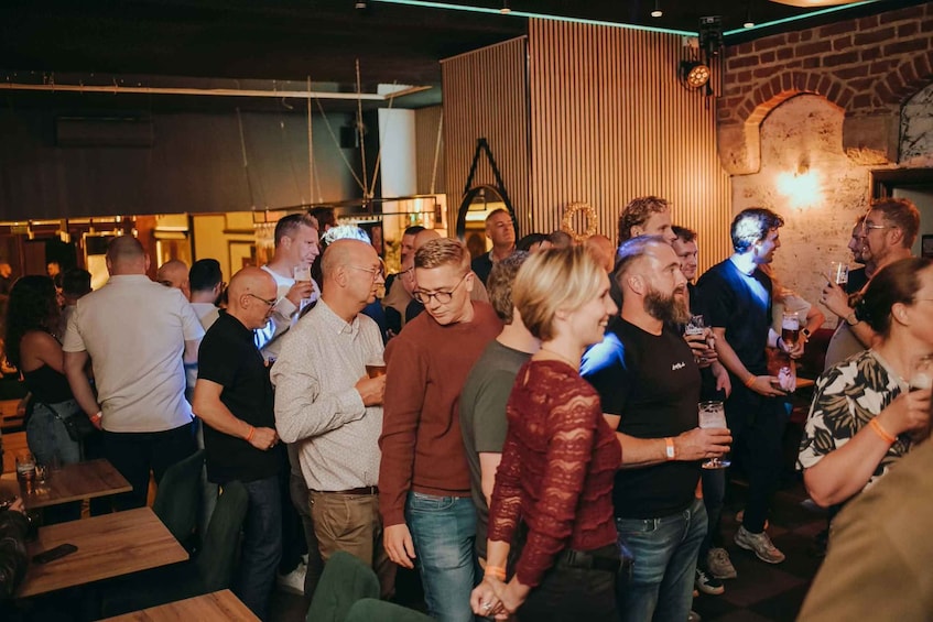 Un groupe de personnes se trouve dans un lieu de rencontre, peut-être un bar ou un restaurant, qui présente un décor avec des lambris en bois et des murs en briques. 3